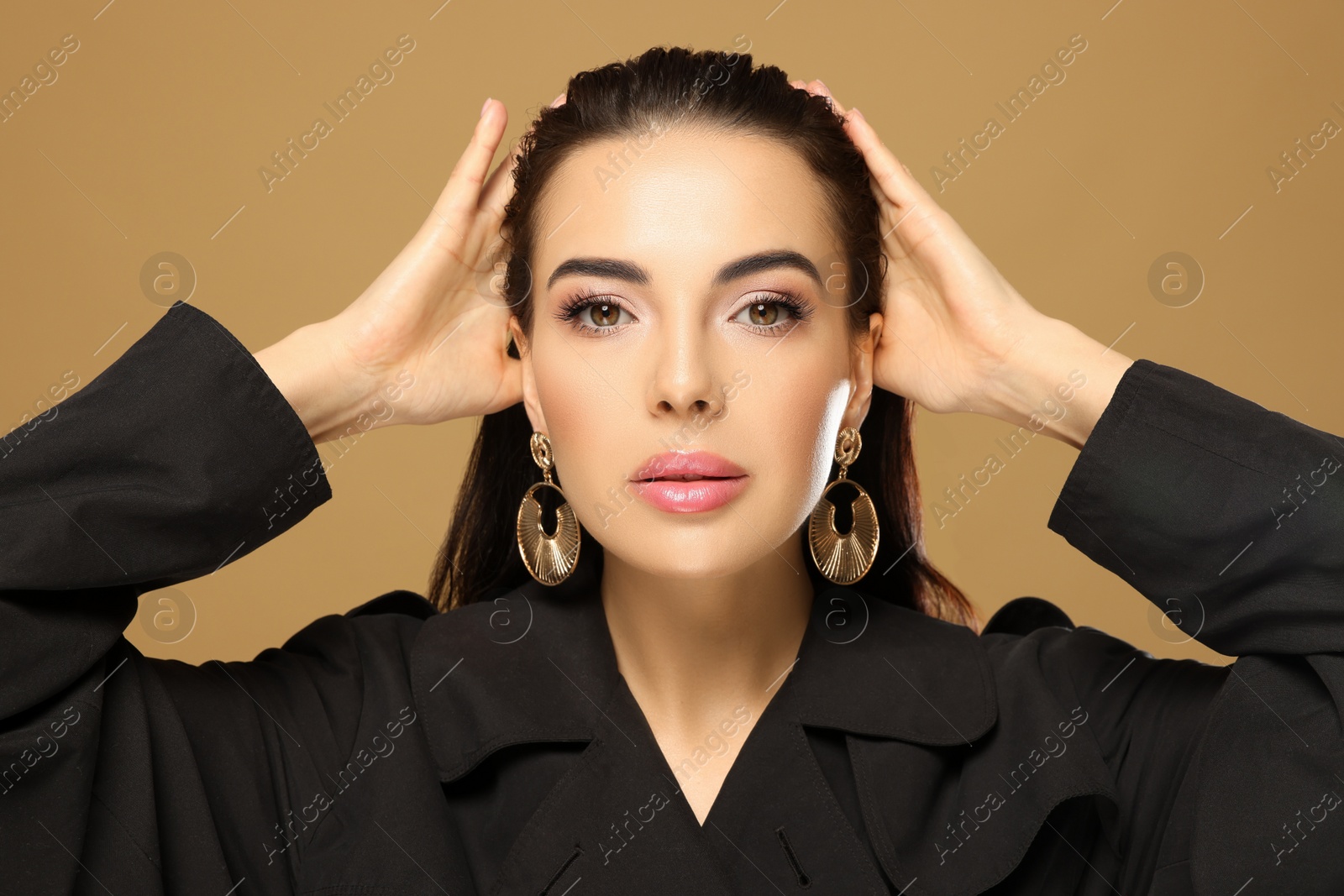 Photo of Portrait of young woman with beautiful makeup on light brown background