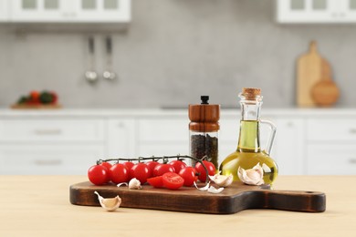 Photo of Fresh cherry tomatoes, oil, garlic and peppercorns on wooden table in kitchen