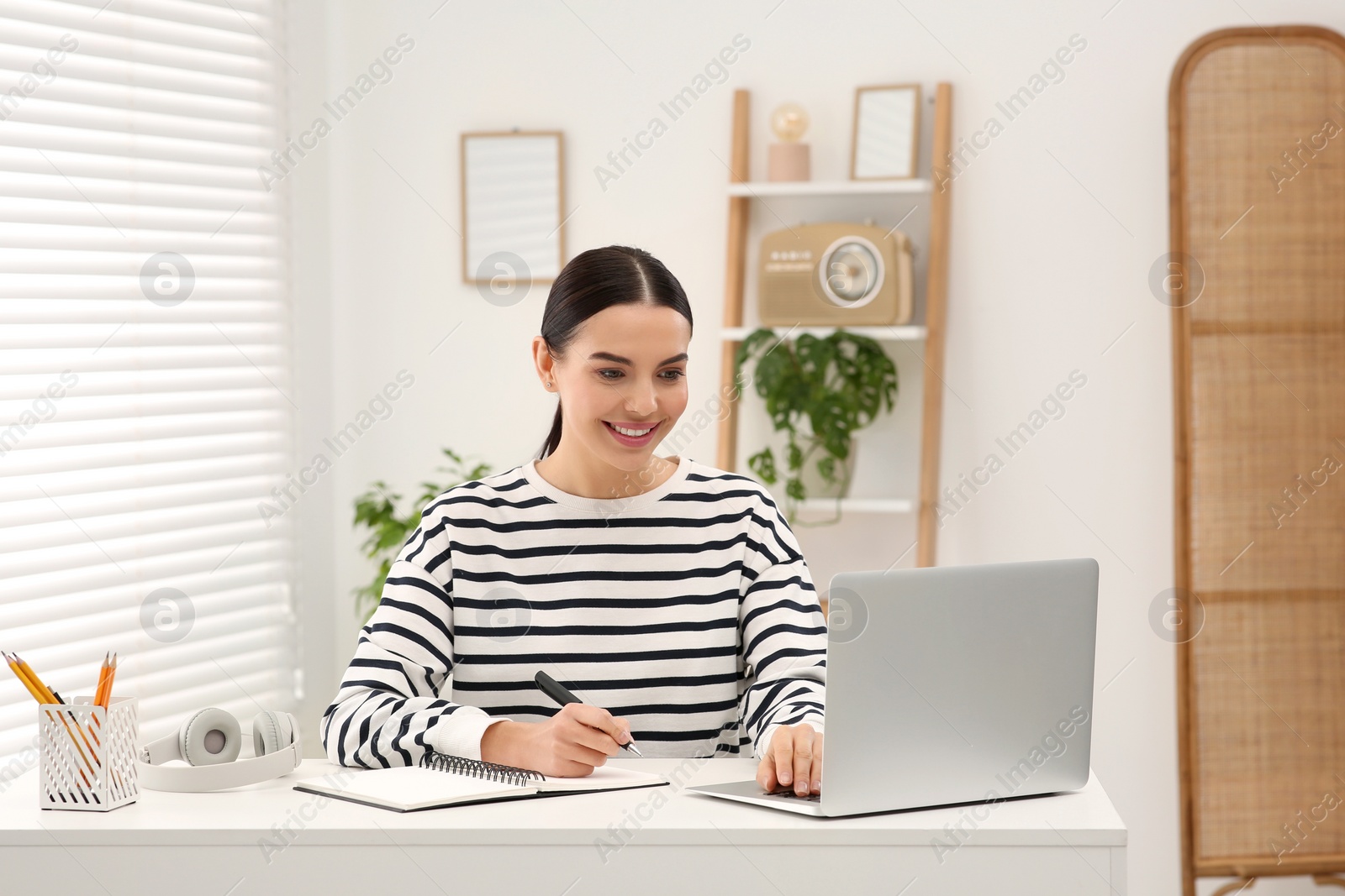 Photo of Woman studying on laptop at home. Online translation course