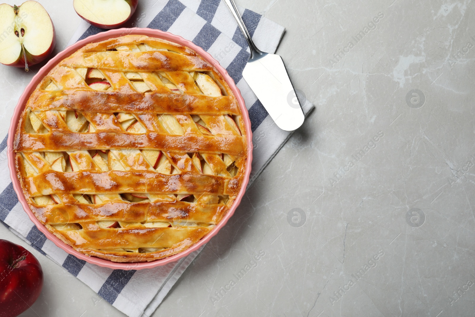 Photo of Traditional apple pie and fruits on light grey table, flat lay. Space for text