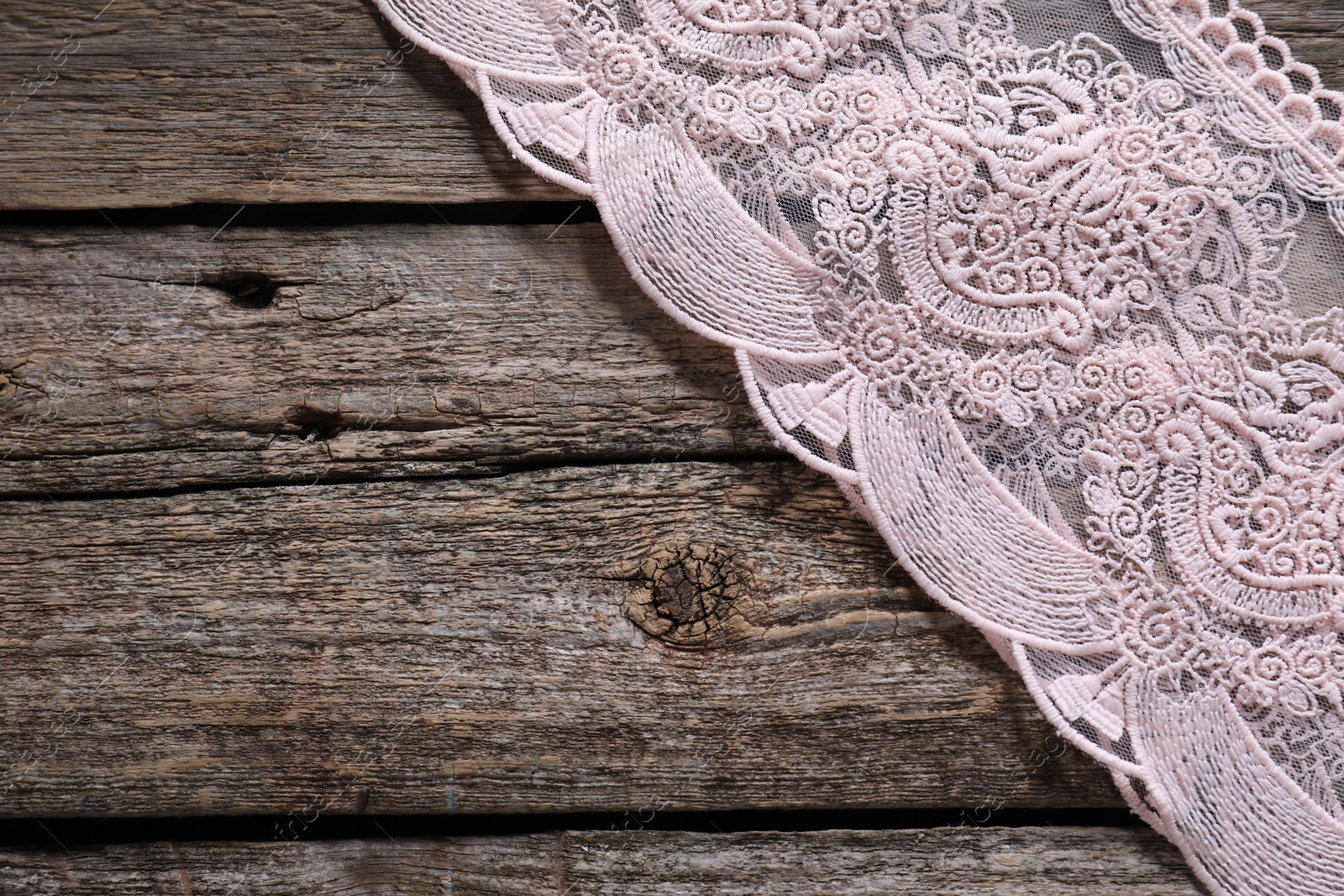 Photo of Beautiful lace on wooden table, top view. Space for text