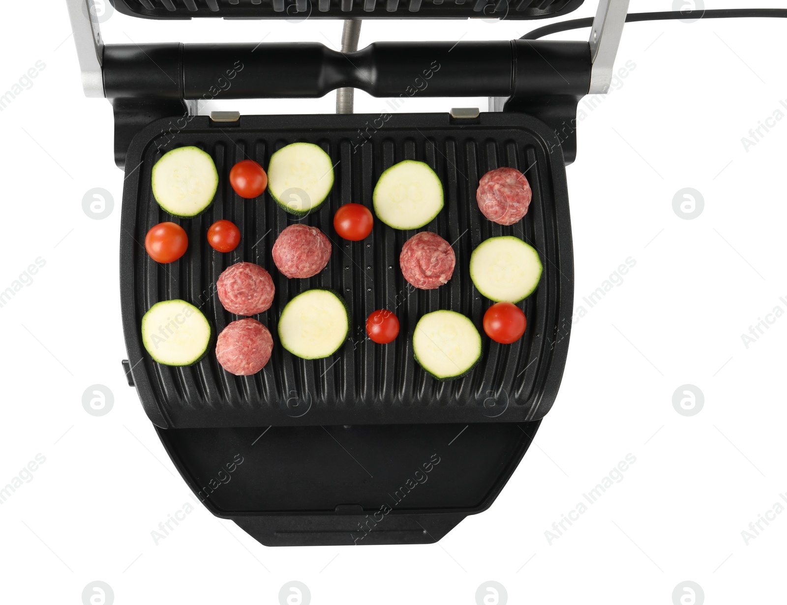 Photo of Electric grill with meat balls, zucchini and tomatoes isolated on white, top view