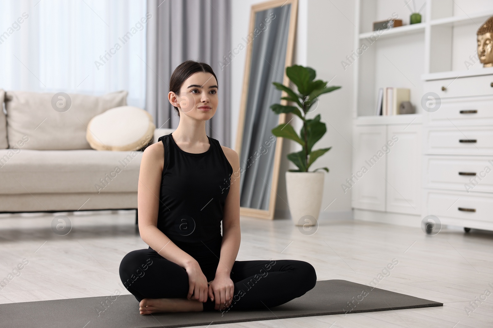 Photo of Beautiful girl meditating on yoga mat at home