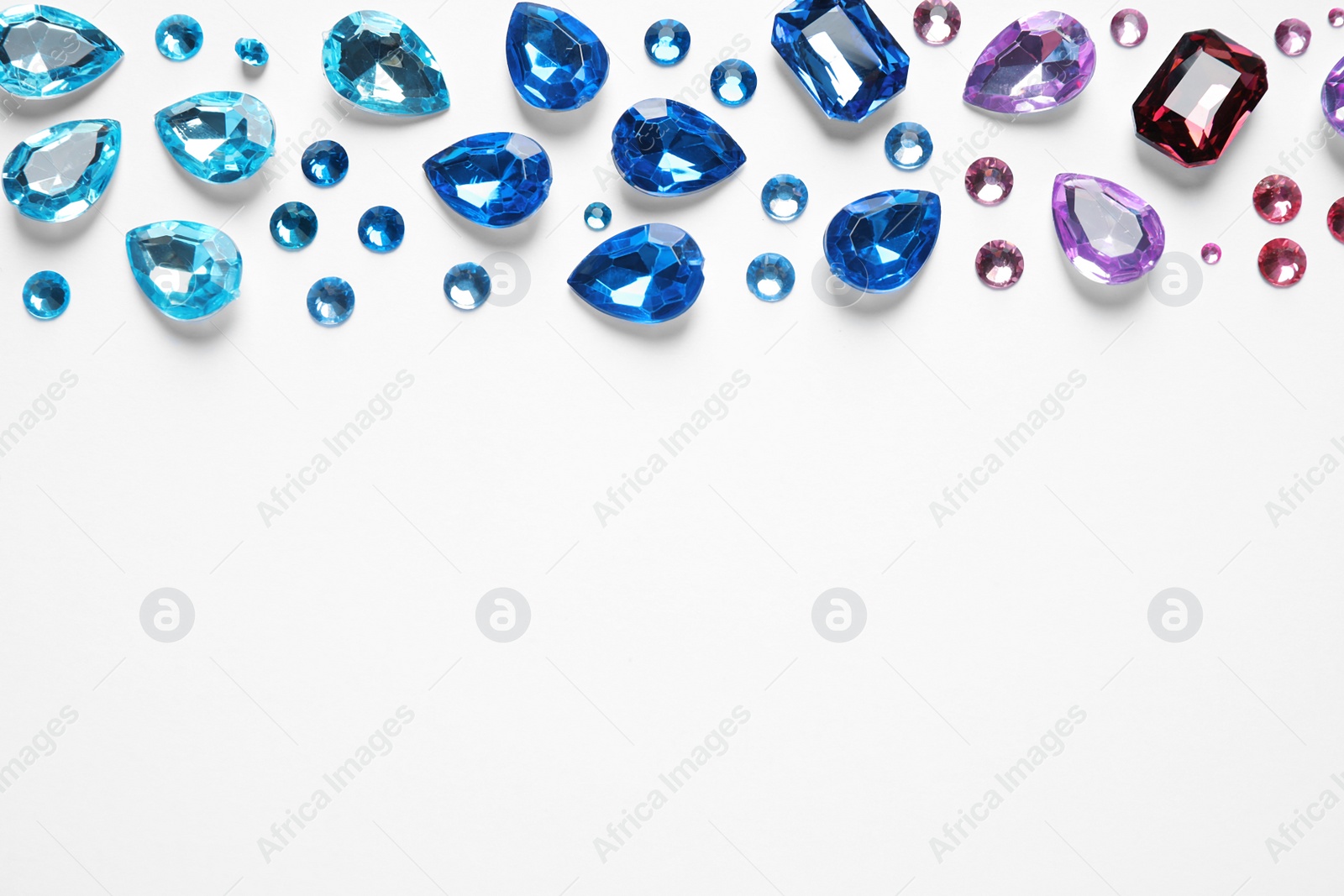 Photo of Different beautiful gemstones on white background, top view