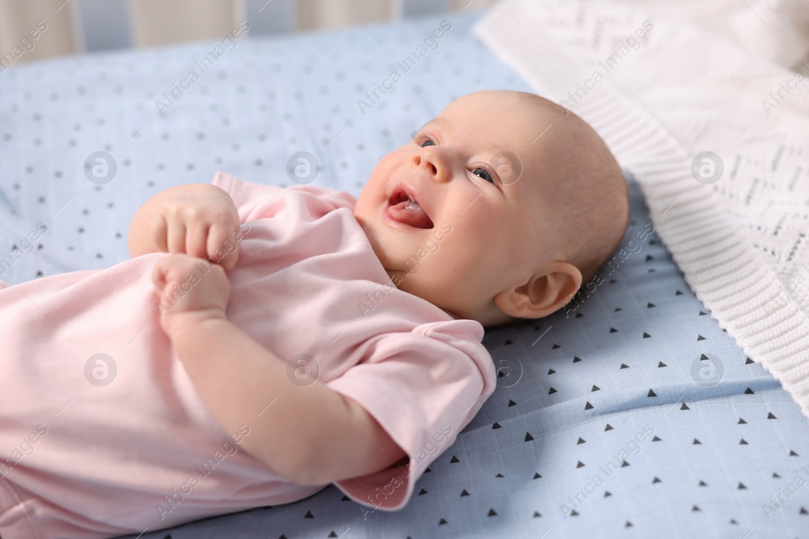 Photo of Cute little baby lying in crib at home