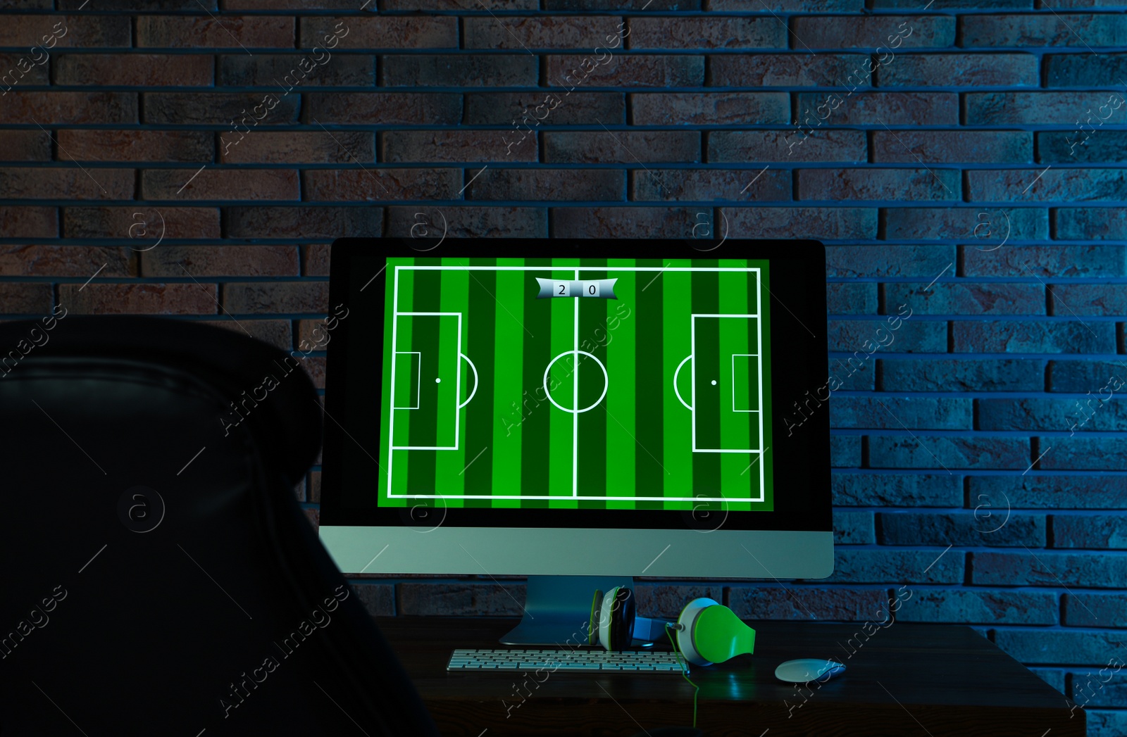 Photo of Modern computer and headphones on table in dark room. Playing video games