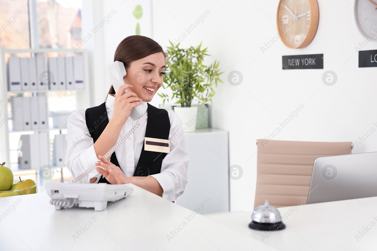 Photo of Female receptionist talking on phone at workplace in hotel