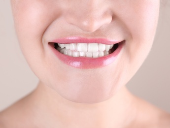 Photo of Young woman with beautiful smile on color background, closeup