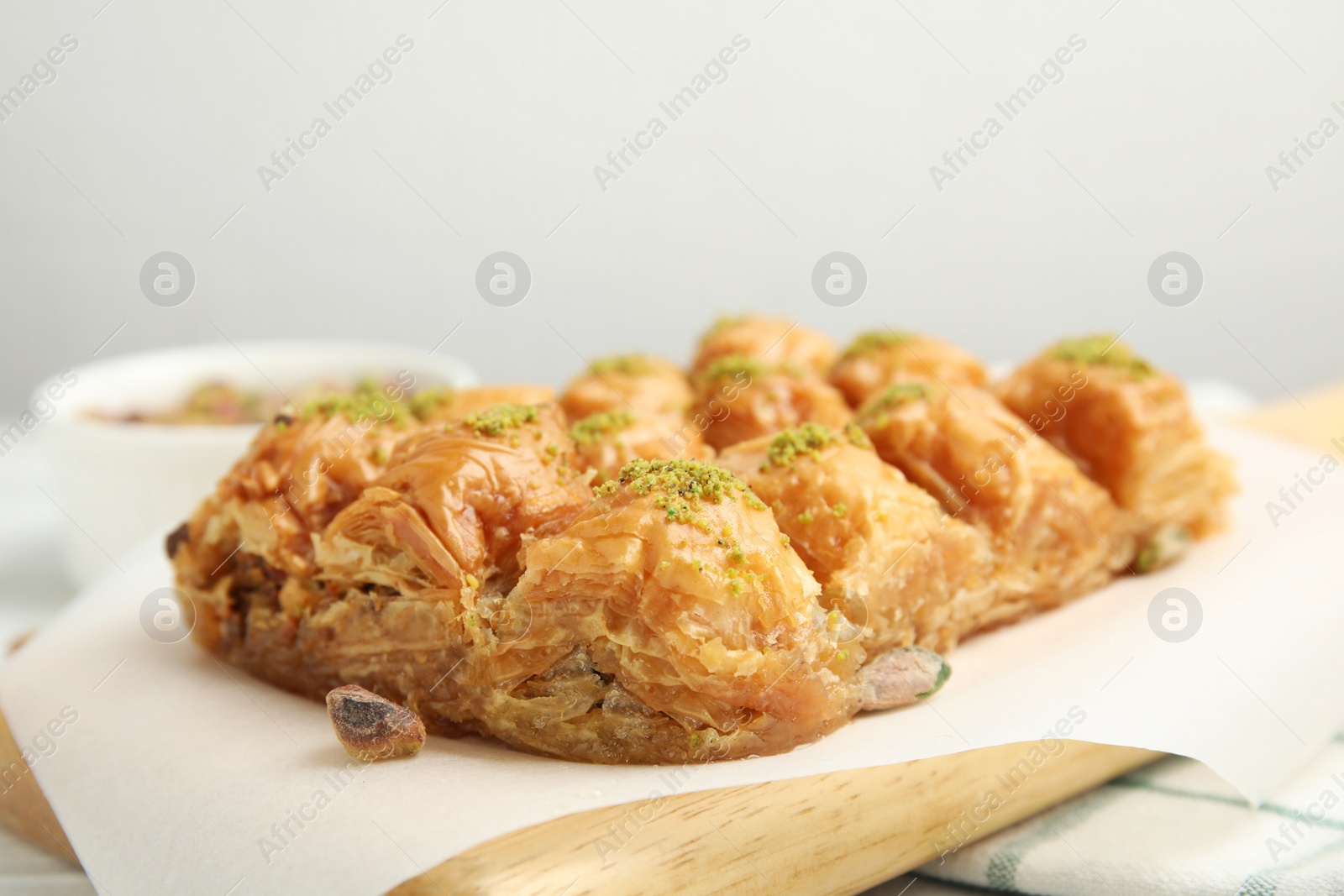 Photo of Delicious sweet baklava with pistachios on board, closeup