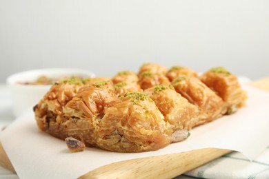 Delicious sweet baklava with pistachios on board, closeup