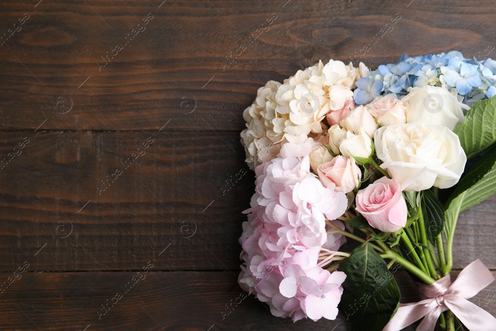 Photo of Bouquet of beautiful hydrangea and rose flowers on wooden background, top view. Space for text