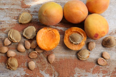 Delicious ripe apricots with stones on wooden table, flat lay