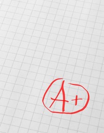 Image of School grade. Red letter A with plus symbol on notebook paper