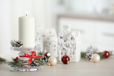 Photo of Christmas composition with glass candlestick on table in room. Space for text