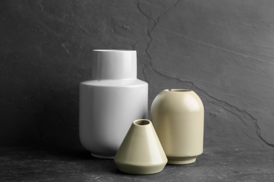 Stylish empty ceramic vases on black table