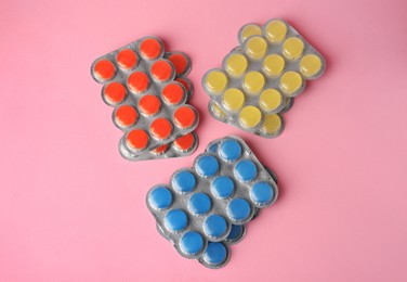 Photo of Blisters with cough drops on pink background, flat lay