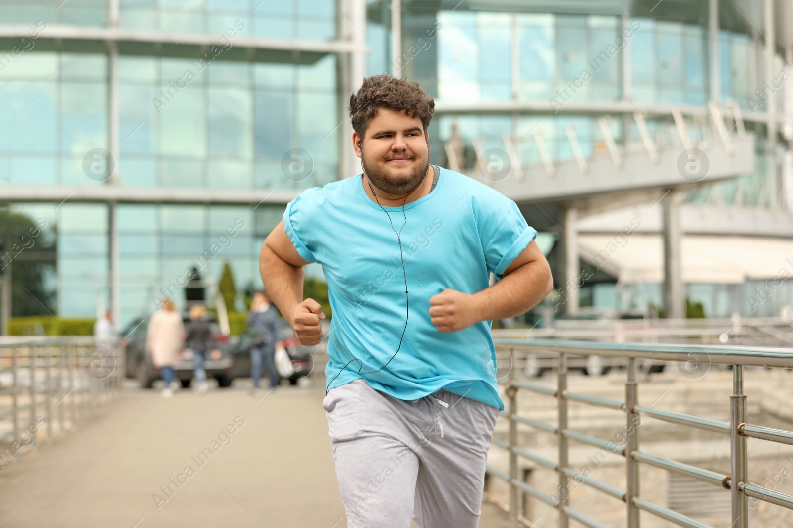 Photo of Young overweight man running outdoors. Fitness lifestyle