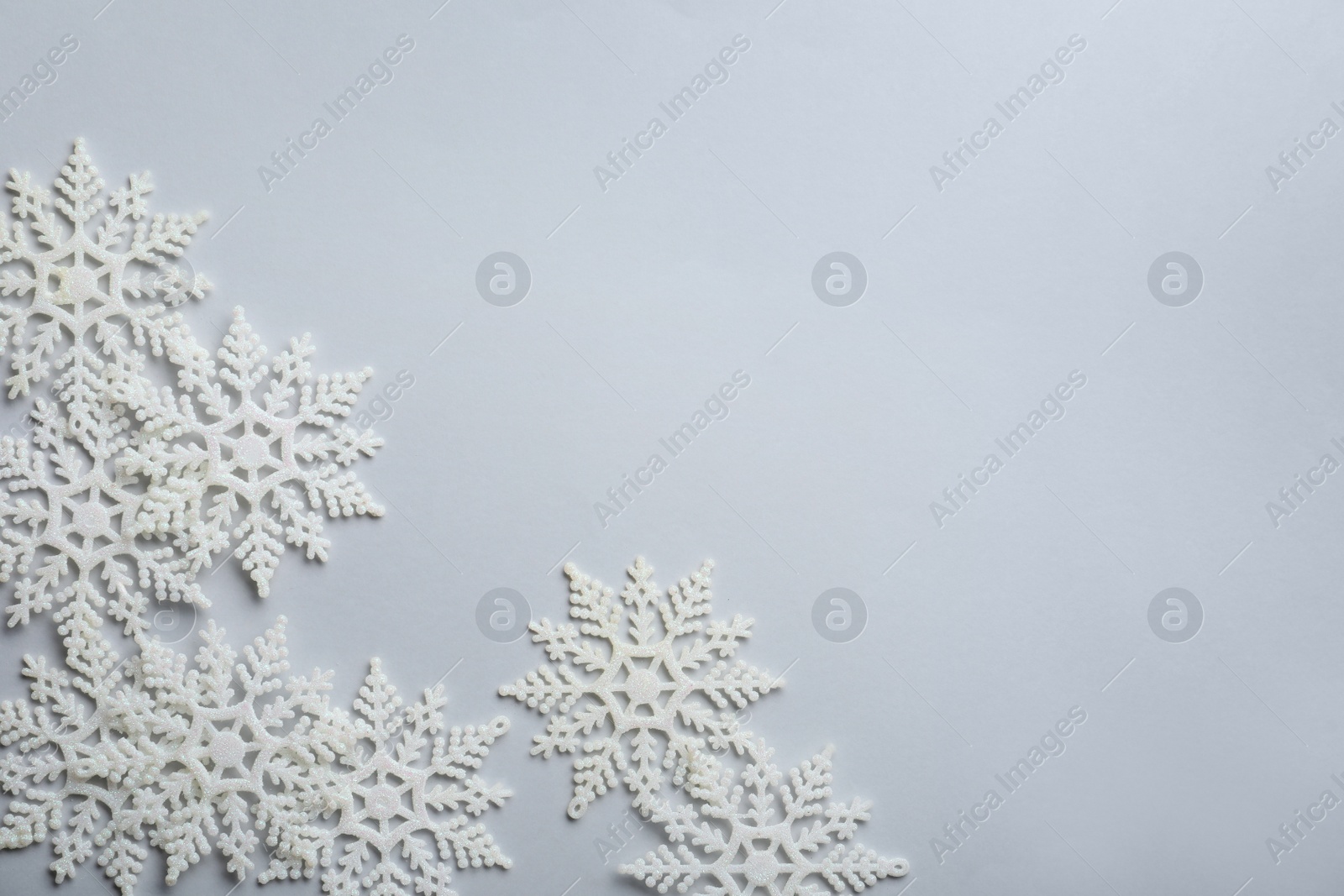 Photo of Beautiful snowflakes on white background, flat lay. Space for text