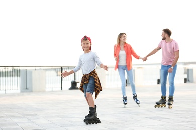 Photo of Happy family roller skating on city street