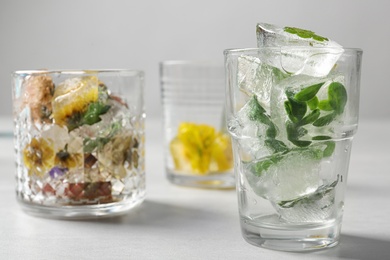 Composition of ice cubes with flowers on light table