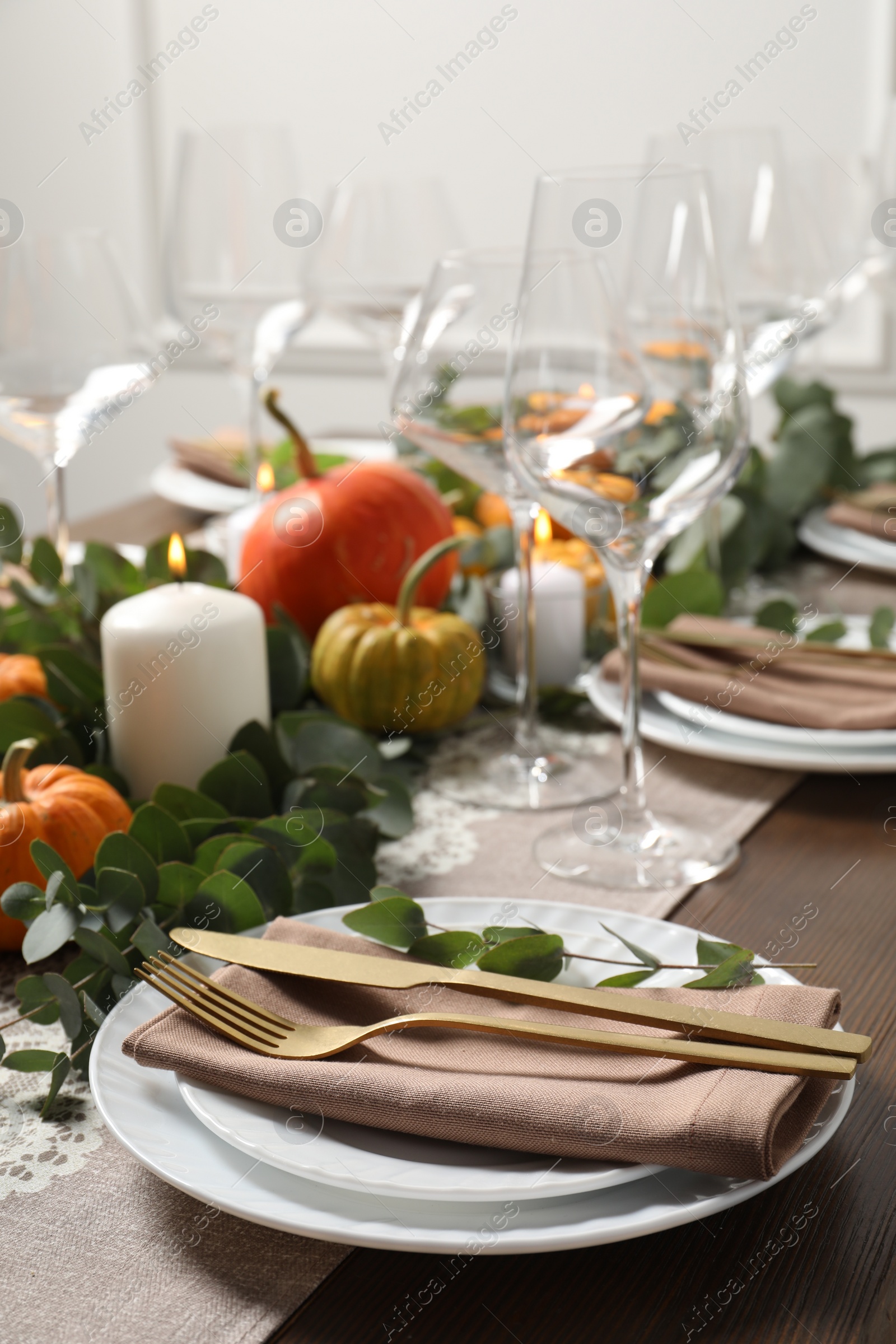 Photo of Beautiful autumn table setting. Plates, cutlery, glasses, pumpkins and floral decor