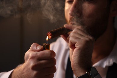Photo of Man lightning cigar at home, closeup view
