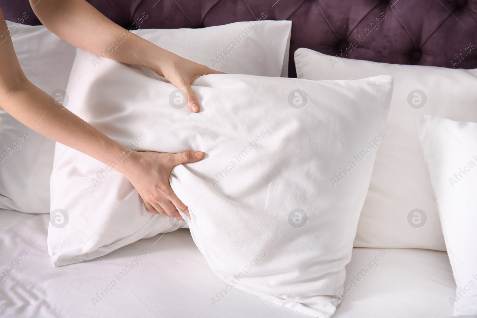 Photo of Young woman making bed, closeup