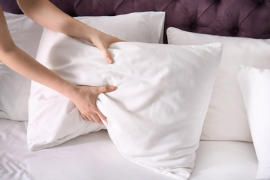 Photo of Young woman making bed, closeup