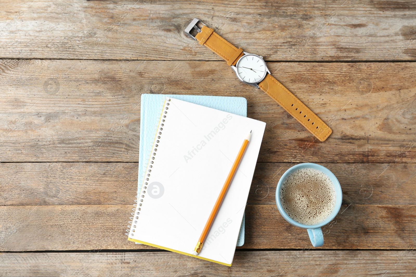 Photo of Flat lay composition with office stationery and cup of coffee on wooden table