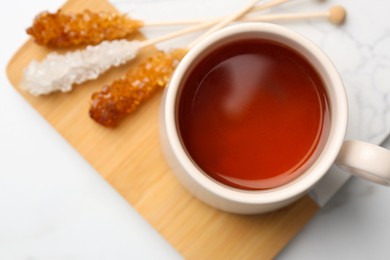 Sticks with sugar crystals served to tea on white table, top view