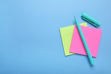 Photo of Paper notes and color marker on light blue background, top view. Space for text