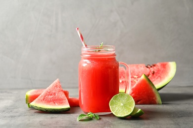 Photo of Summer watermelon drink in mason jar and sliced fruits on table