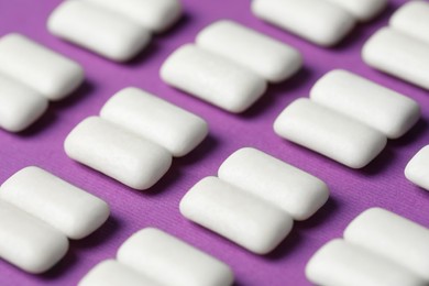 Photo of Tasty white bubble gums on purple background, closeup