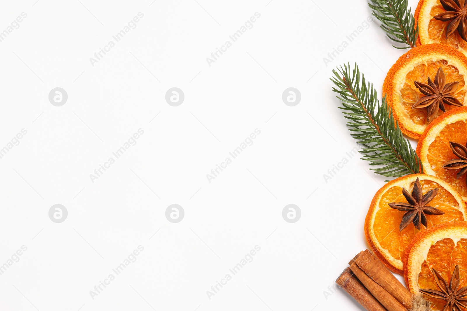 Photo of Dry orange slices, cinnamon sticks, fir branches and anise stars on white background, flat lay. Space for text