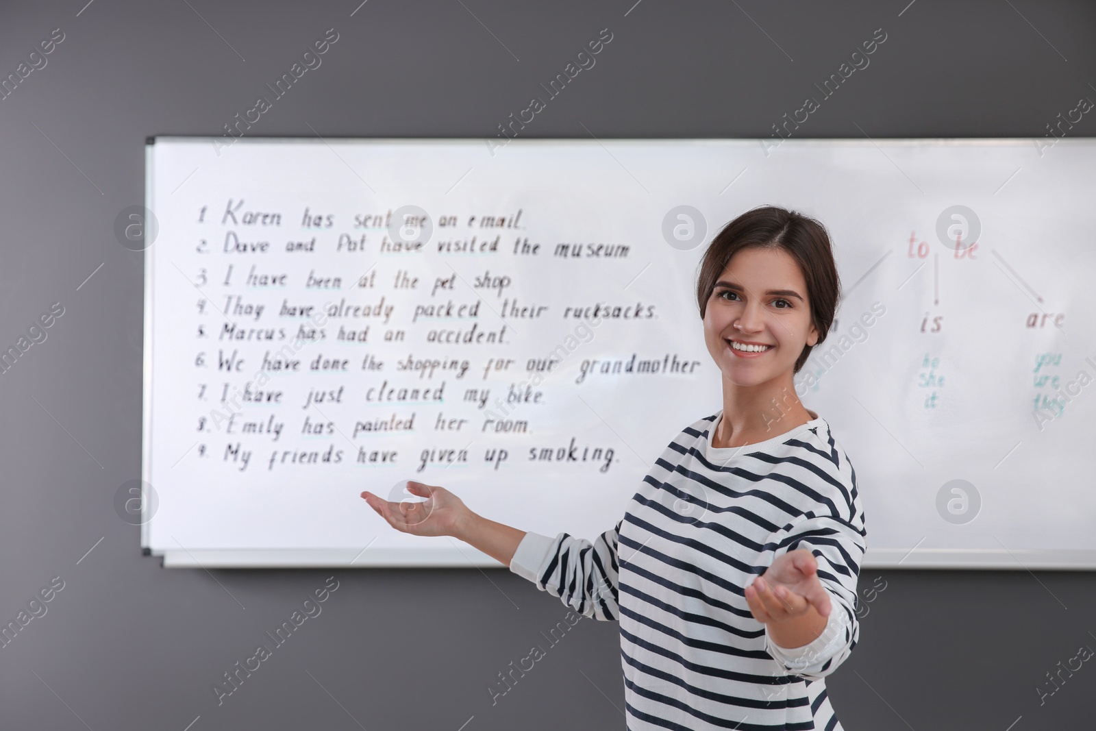 Photo of Happy English teacher near whiteboard at lesson
