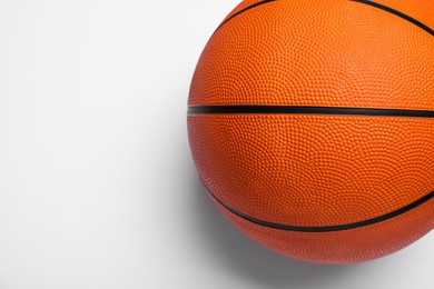 Photo of Orange ball on white background, top view. Basketball equipment