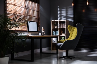 Photo of Stylish room interior with modern computer and comfortable office chair