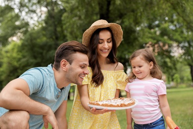 Happy family having picnic in park on summer day