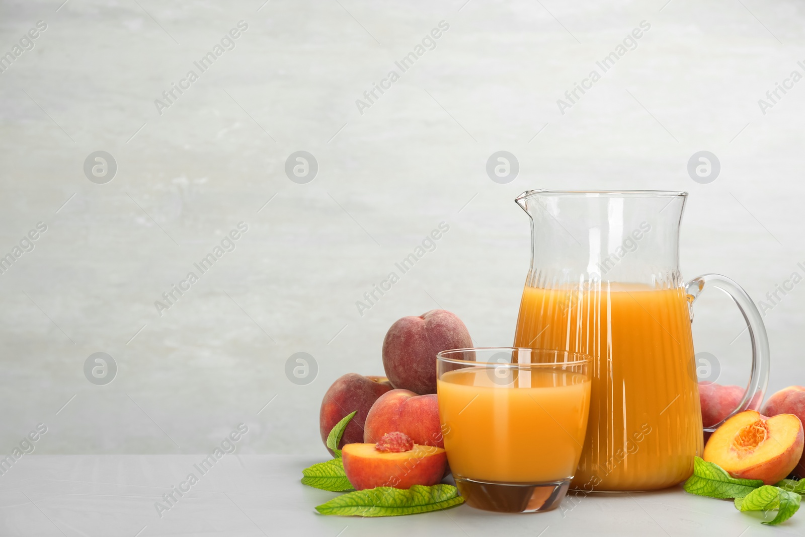 Photo of Natural freshly made peach juice on light table. Space for text