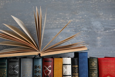 Stack of hardcover books on grey wooden background