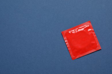 Photo of Condom package on blue background, top view and space for text. Safe sex