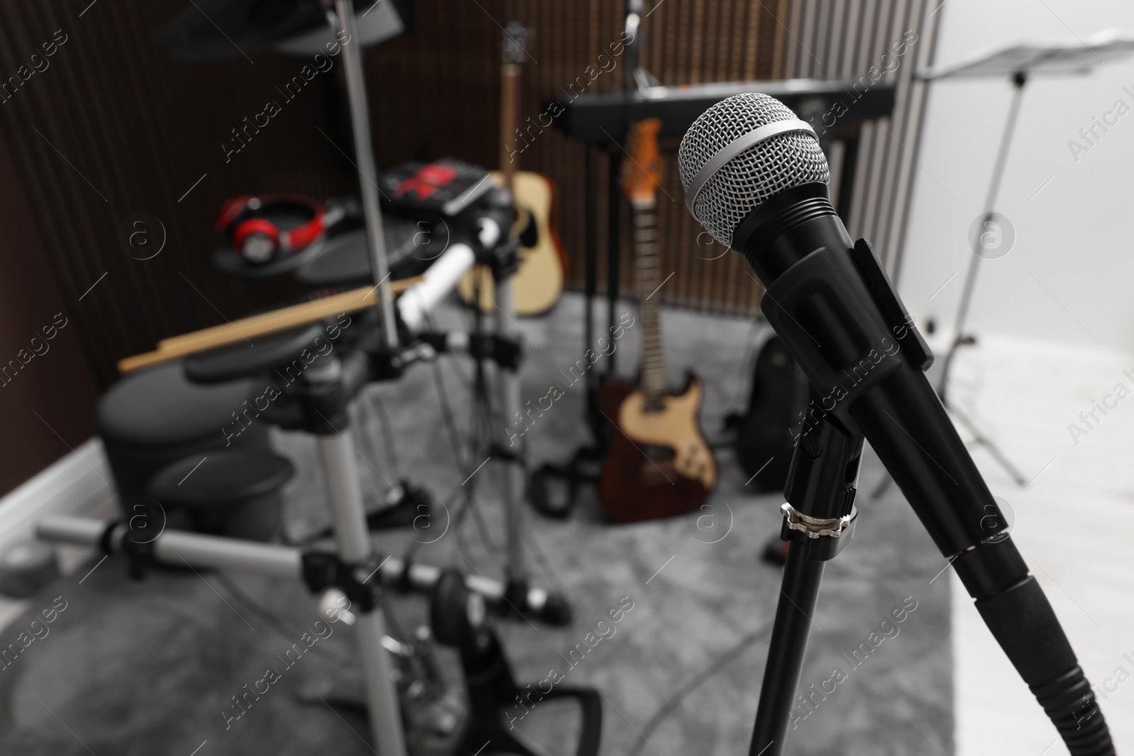 Photo of Modern microphone at recording studio, space for text. Music band practice