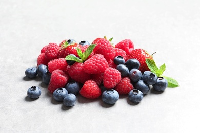 Photo of Raspberries, strawberries and blueberries on table