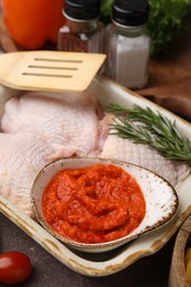 Photo of Fresh marinade, raw chicken and rosemary on table, closeup