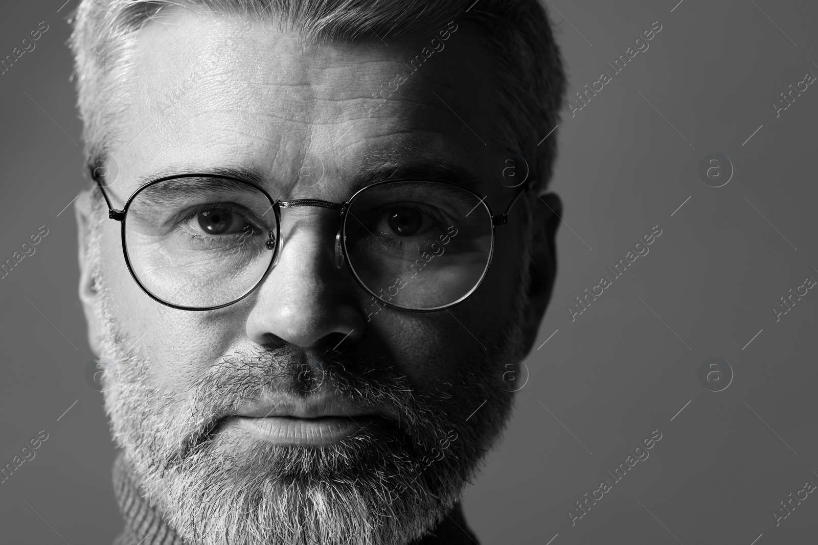 Photo of Portrait of handsome man on grey background, space for text. Black and white effect