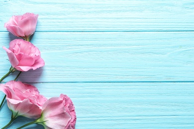 Photo of Flat lay composition with beautiful Eustoma flowers on wooden background