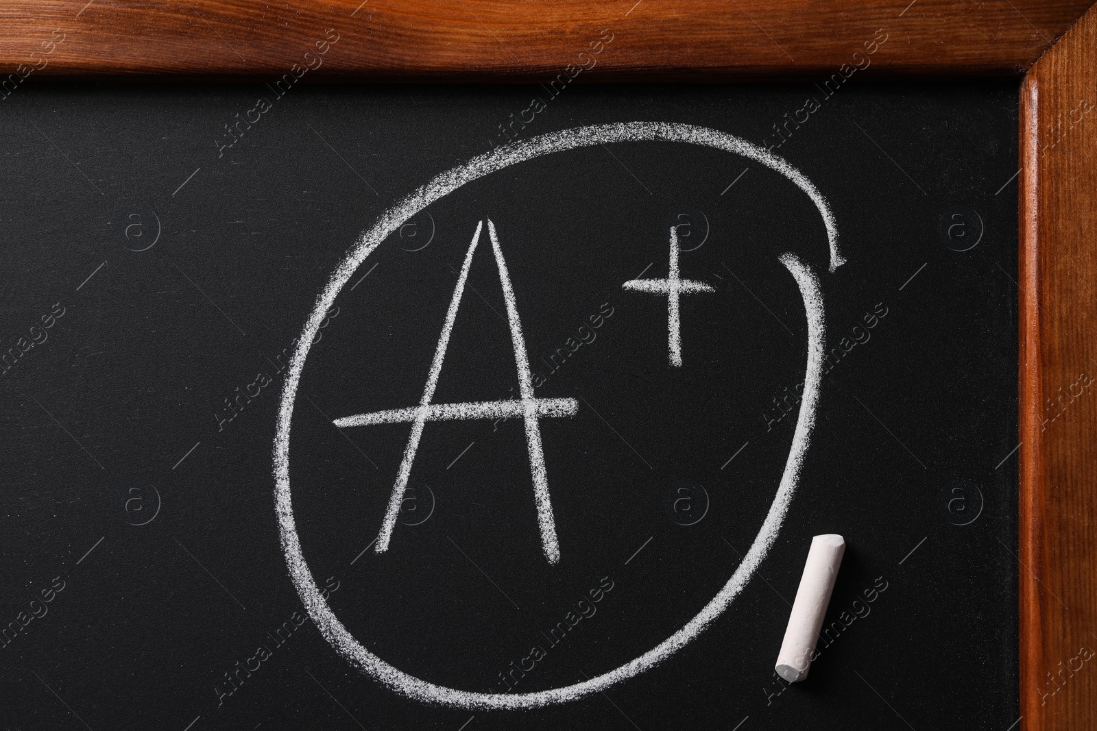 Photo of School grade. Letter A with plus symbol and chalk on blackboard, top view