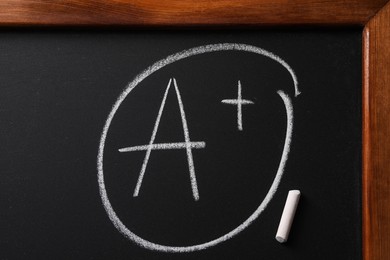 Photo of School grade. Letter A with plus symbol and chalk on blackboard, top view