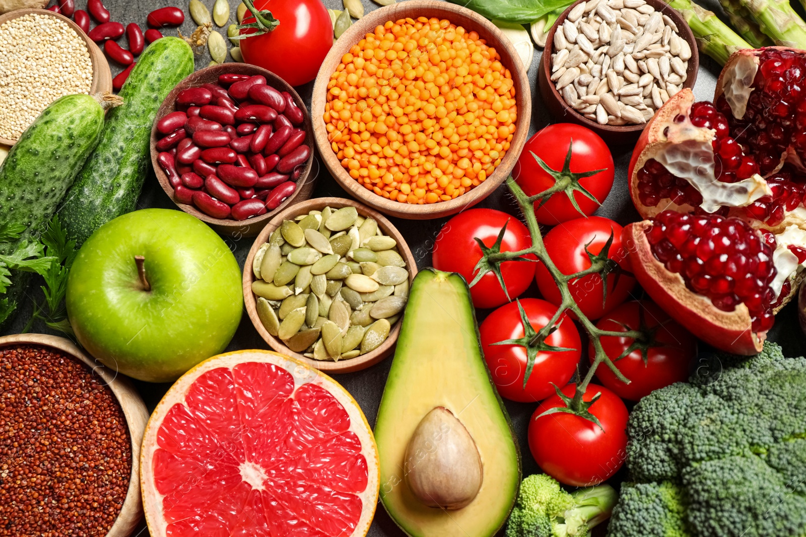 Photo of Fresh vegetables, fruits and seeds on grey table, flat lay