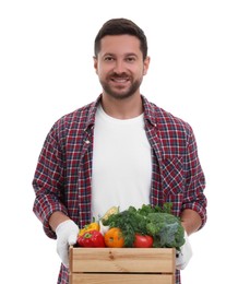 Harvesting season. Happy farmer holding wooden crate with vegetables on white background